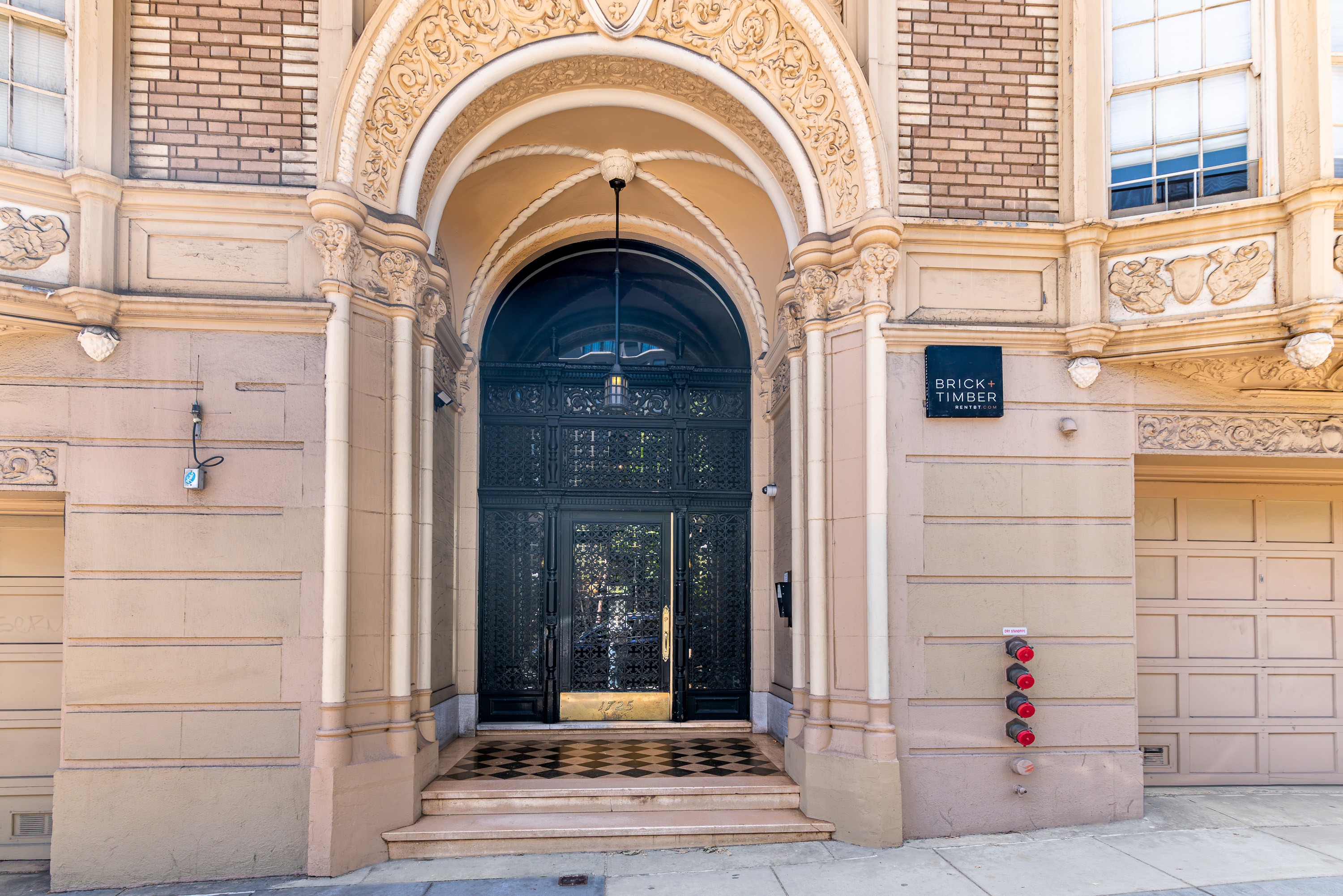 The entrance to a building with a black door and a sign that reads "BRICK".